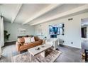 Open living area with hardwood floors, neutral tones, modern decor, and a kitchen view at 2525 S Dayton Way # 1003, Denver, CO 80231