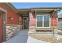 Inviting home entrance with stone accents, neutral siding and a well-maintained walkway at 4533 Angelina Cir, Longmont, CO 80503