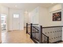 Bright foyer with tile flooring, white walls, and stairs with decorative black iron railing at 4533 Angelina Cir, Longmont, CO 80503