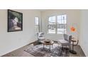 Bright sitting area with large windows, stylish chairs, accent table, and decorative artwork at 4533 Angelina Cir, Longmont, CO 80503