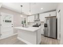 Bright modern kitchen with island, stainless steel appliances, white cabinets, and stylish pendant lights at 1269 N Revere St, Aurora, CO 80011