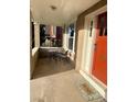 Charming front porch with seating area, bright red door, and 'HOME' welcome mat at 3259 Lowell Blvd, Denver, CO 80211