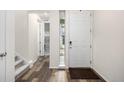 Bright foyer featuring stylish floors, a staircase, and a white front door at 9723 Bennett Peak St, Littleton, CO 80125
