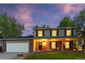 Welcoming two-story home with brick accents, a covered porch, and a lush green lawn, perfect for families at 504 E Otero Ct, Littleton, CO 80122