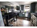 Updated kitchen featuring stainless steel appliances, gray cabinets, and stylish breakfast bar at 7620 Hooker St, Westminster, CO 80030