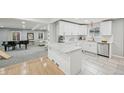 Modern, open kitchen featuring white cabinets, marble countertops, stainless steel appliances, and an island at 3285 N Monaco Pkwy, Denver, CO 80207