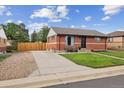 Charming single-story brick home with well-maintained lawn and inviting outdoor seating at 7833 Raritan St, Denver, CO 80221