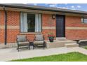 Inviting front porch with seating, flower pot, and a well-maintained lawn at 7833 Raritan St, Denver, CO 80221