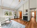 Cozy living room features a fireplace, hardwood floors, and a view of the front yard at 10862 Albion Dr, Thornton, CO 80233