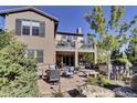 An expansive backyard features a stone patio with comfortable seating and mature trees at 10553 Fairhurst Way, Highlands Ranch, CO 80126