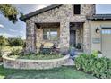 Inviting stone accented front porch and front yard with a colorful garden and lush lawn at 10553 Fairhurst Way, Highlands Ranch, CO 80126