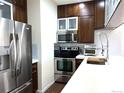 Modern kitchen featuring stainless steel appliances, subway tile backsplash, and white countertops at 1000 E 1St Ave # 405, Denver, CO 80218