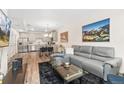 Open-concept living area features modern decor, stainless steel appliances, and a comfortable gray sofa on wood-look flooring at 5745 S Buchanan Ct # C, Aurora, CO 80016