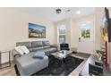 Inviting living room features a comfortable gray couch, a sleek glass table, and ample natural light from the front door at 5745 S Buchanan Ct # C, Aurora, CO 80016