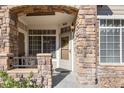 Inviting entryway with stone arch, a wreath, and a small bench at 12711 Colorado Blvd # 912, Thornton, CO 80241