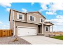 Charming two-story home showcasing a two-car garage, light brown siding, and an expansive driveway at 2175 Alyssa St, Fort Lupton, CO 80621