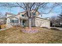 Inviting two-story home featuring a well-kept lawn and a brick-lined tree bed at 1033 Quarterhorse Trl, Castle Rock, CO 80104
