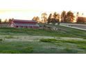 Exterior view of a red barn with horses grazing in the surrounding field at 2470 Driftwood, Elizabeth, CO 80107