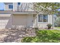 Welcoming home entrance with a small lawn and planted pot, plus an attached one-car garage at 15976 E Radcliff Pl # A, Aurora, CO 80015