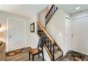 The home's entry foyer features hardwood floors and a staircase with wood banister and carpeted steps at 15976 E Radcliff Pl # A, Aurora, CO 80015