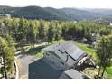 Beautiful aerial view showcasing a house with solar panels surrounded by lush greenery and trees at 8 Sioux Trl, Evergreen, CO 80439