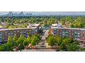 Panoramic aerial view of Central Park neighborhood with buildings, lush trees, and the Denver skyline in the distance at 7700 E 29 Ave # 304, Denver, CO 80238