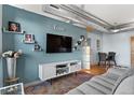 This living room offers modern decor and design, exposed ductwork, and a view into the dining area at 7700 E 29 Ave # 304, Denver, CO 80238