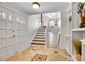 Bright foyer with tiled flooring, a staircase leading upstairs, and a coat closet at 11488 E Amherst S Cir, Aurora, CO 80014