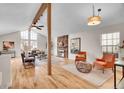 Spacious living room with a stone fireplace, hardwood floors, vaulted ceilings, and large windows at 11488 E Amherst S Cir, Aurora, CO 80014