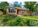 Charming red-brick home with manicured landscaping, bay window, and front porch at 2240 S Clermont St, Denver, CO 80222