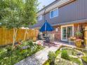 Serene backyard patio with dining set, lush landscaping, and a privacy fence, perfect for outdoor entertaining at 5525 S Lowell Blvd, Littleton, CO 80123