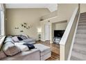 Inviting living room with vaulted ceilings, hardwood floors, and a comfortable gray sectional sofa perfect for relaxation at 1099 S Walden Way # 205, Aurora, CO 80017