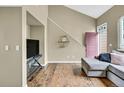 Open-concept living space with a high ceiling, hardwood flooring, and a stylish gray sectional at 1099 S Walden Way # 205, Aurora, CO 80017
