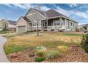 Inviting two-story home with a well-kept lawn, a brick-accented garage, and a charming covered front porch at 8101 S Quatar Cir, Aurora, CO 80016