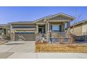 Inviting single-Gathering home featuring a covered porch, stone accents, and an attached two car garage at 8501 S Rome Way, Aurora, CO 80016
