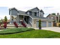 Attractive two-story home with manicured landscaping leading to a two-car attached garage at 6888 Howell St, Arvada, CO 80004