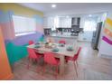 Bright dining area featuring modern decor, a colorful accent wall, and an open flow to the kitchen at 7799 Pecos St, Denver, CO 80221
