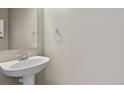 Powder room with a pedestal sink and chrome fixtures at 5779 Ceylon St, Denver, CO 80249