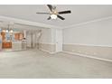Open-concept living room with neutral carpet, fan and access to the kitchen at 5779 Ceylon St, Denver, CO 80249