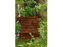 Close up of a wooden front porch entrance with stairs and lush greenery surrounding the space at 10525 Hobbit Ln, Westminster, CO 80031