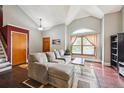 Cozy living room featuring hardwood floors, vaulted ceiling, and a large window at 10525 Hobbit Ln, Westminster, CO 80031