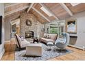 Cozy living room featuring a stone fireplace, vaulted wood ceilings, and ample natural light at 5145 S Logan Dr, Littleton, CO 80121