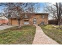 Charming stone facade home with a paved walkway leading to the front door and manicured front yard at 1390 S Ammons St, Lakewood, CO 80232