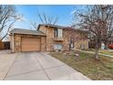 Charming stone facade home with a paved driveway and manicured front yard, perfect for curb appeal at 1390 S Ammons St, Lakewood, CO 80232