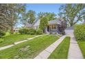Beautifully landscaped front yard with a walkway leading to a charming gray home and detached garage at 1640 Pontiac St, Denver, CO 80220