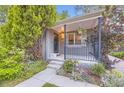 Inviting covered front porch with hanging flower baskets and tasteful landscaping at 1640 Pontiac St, Denver, CO 80220