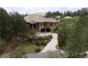 An exterior view shows a house with a lush green yard and mature trees at 214 Equinox Dr, Castle Rock, CO 80108