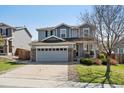 Charming two-story home with stone accents, a spacious driveway, and a manicured lawn at 13818 Krameria St, Thornton, CO 80602