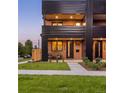 Contemporary townhome boasts a brick facade, covered balcony, and stylish front entrance with modern accents at 2090 Eliot St, Denver, CO 80211