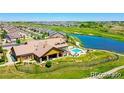 An aerial view of a community clubhouse, pool, and adjacent pond at 19802 E 54Th Ave, Denver, CO 80249